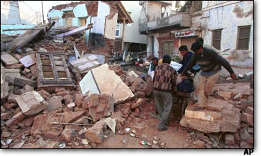 Ahmedabad'da deremzedeler, enkaz altndan kurtarlan eyalarn yaadklar yere, ak alanlara tayorlar.